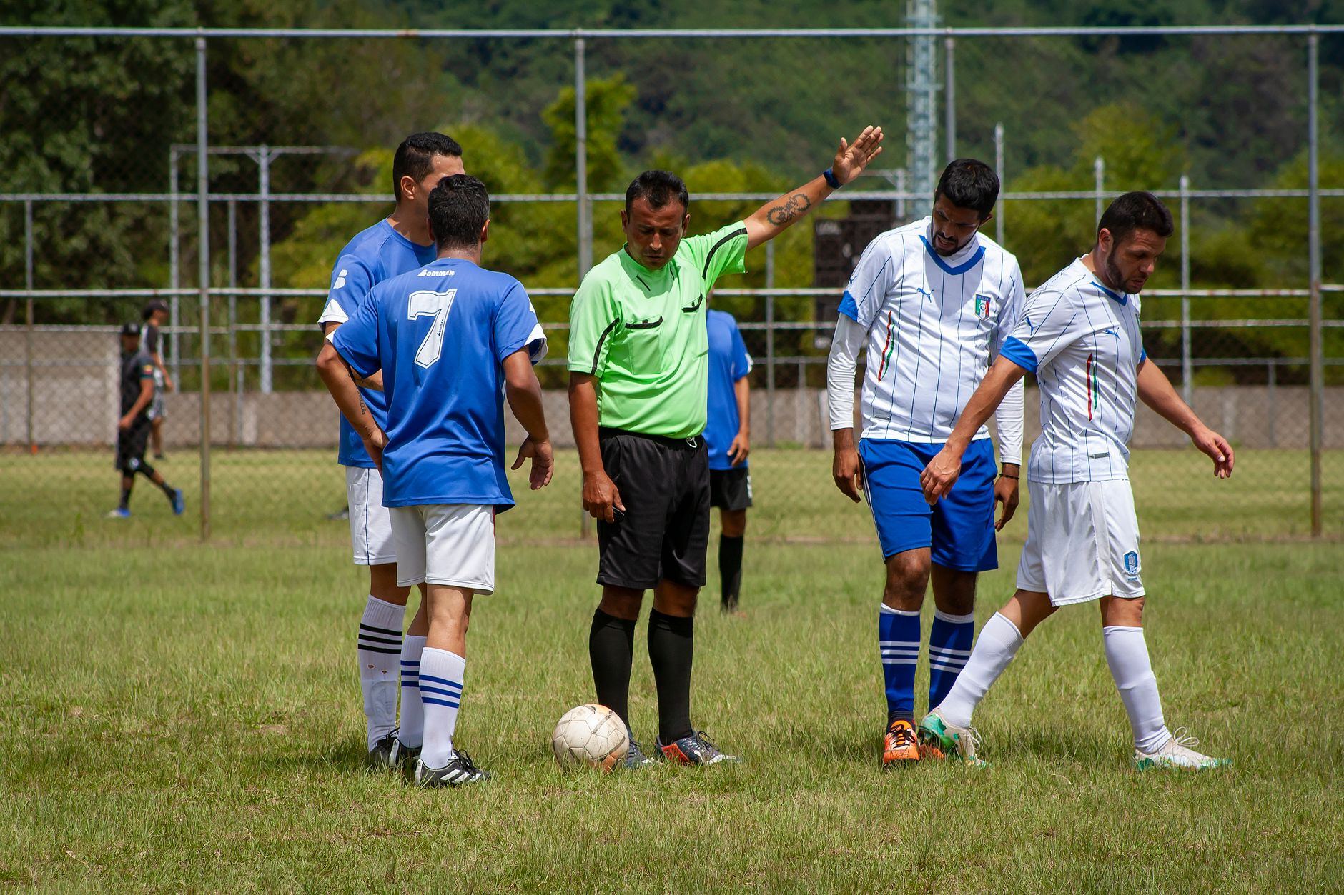 Árbitro em campo durante uma partida de futebol amador