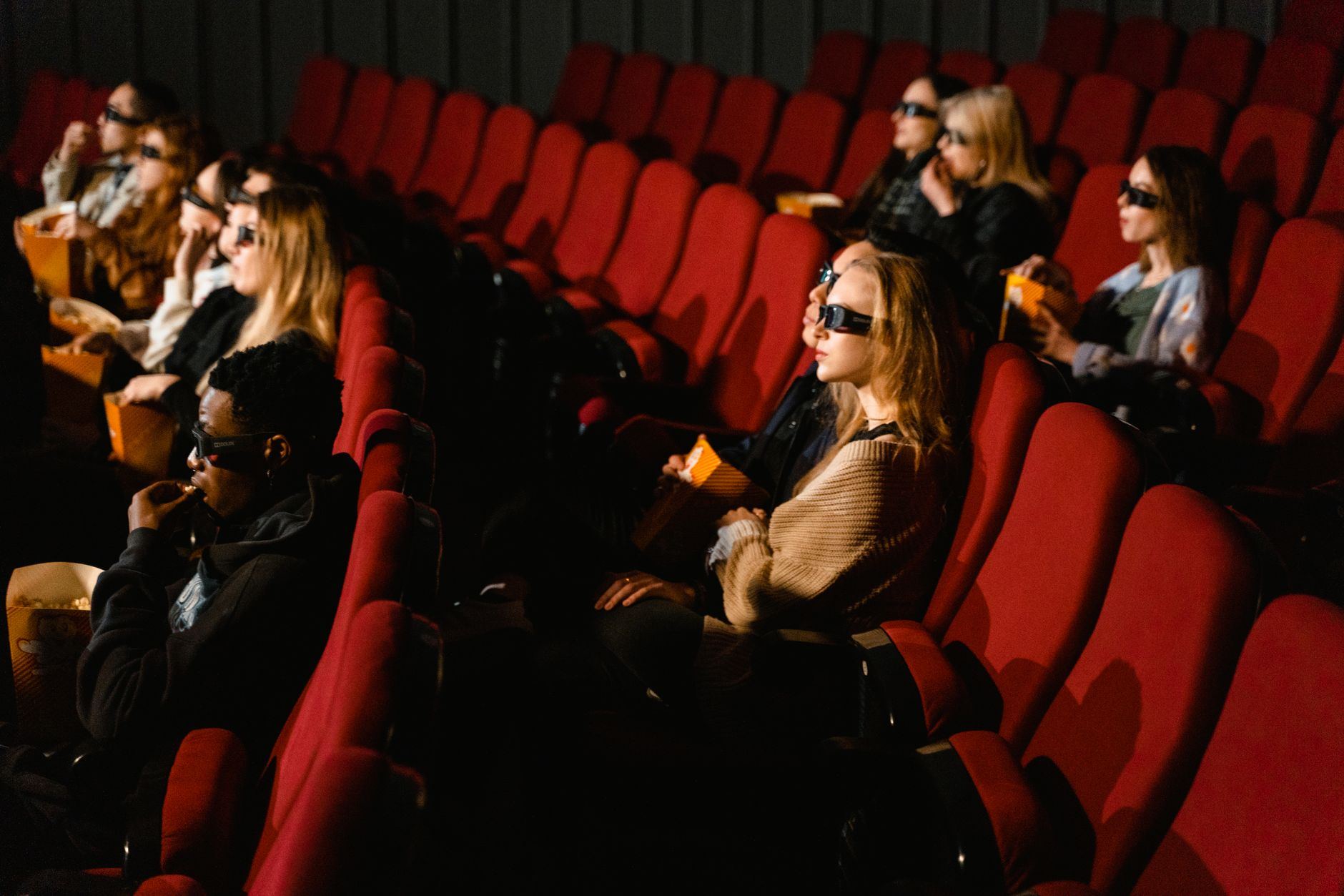 Plateia assistindo a uma projeção de cinema numa sala escura